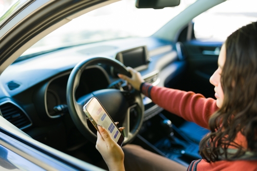 Girl driving while using phone – distracted driving accident lawyer perspective