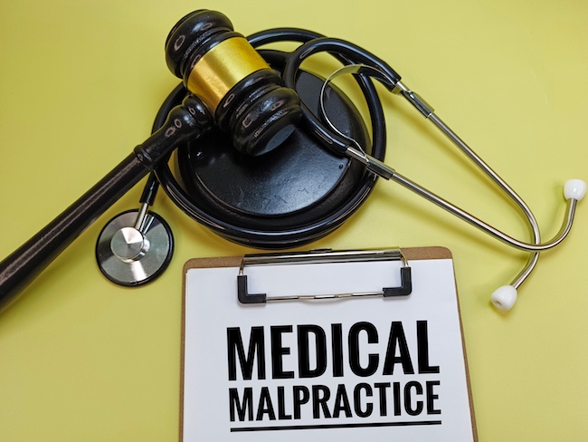 Medical malpractice claims documentation with a stethoscope and gavel representing legal action.