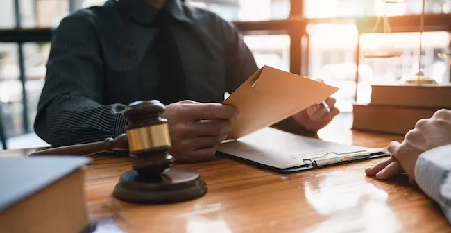 Patient injury compensation case being reviewed by an attorney during legal consultation meeting.