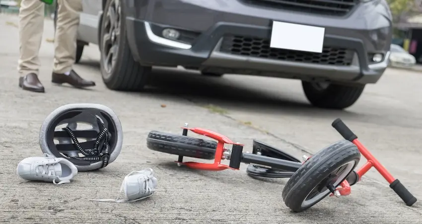 Overturned a child's tricycle and helmet on the street near a vehicle depicting a tragic wrongful death accident scene in South Carolina.