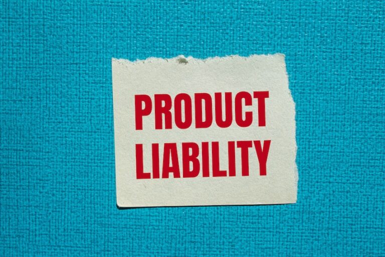 A torn paper note is displaying product liability text in red letters on a dark turquoise background symbolizing product liability injuries and legal matters in South Carolina.