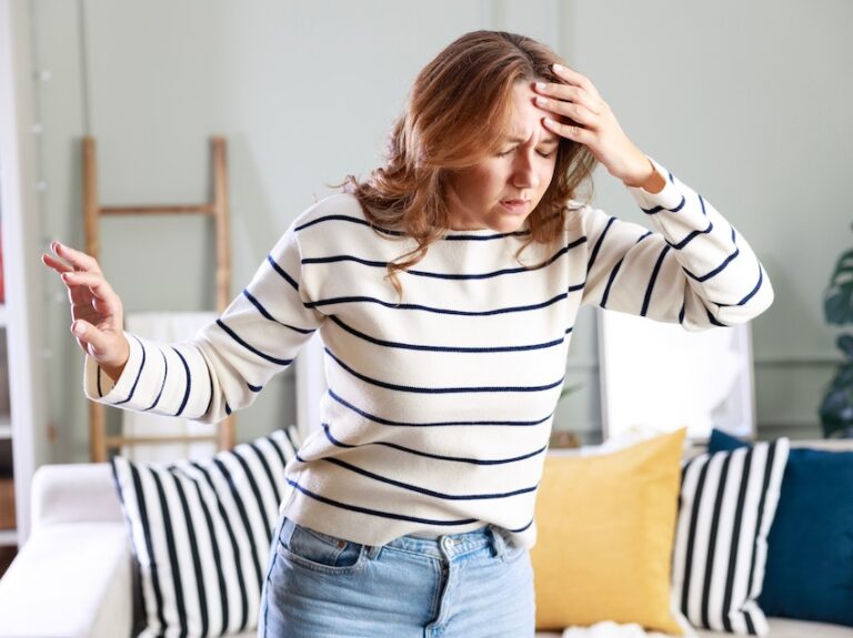 A woman is experiencing dizziness and disorientation from a brain injury and is holding her head in distress in South Carolina.