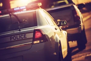 Police car preparing to pull over a suspected drunk driver at night — representing DUI accident enforcement and legal cases handled by Beaufort DUI accident lawyers.