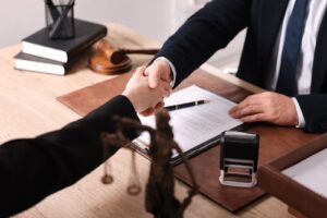 Attorney shaking personal injury client's hand over a contract