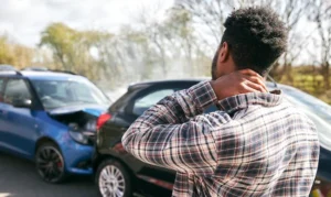 Man holding his neck signifying an injury after a car crash between two vehicles and in need of a personal injury lawyer in charleston south carolina.