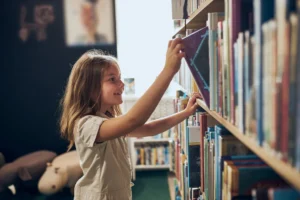 Beaufort County Book Ban - child pulls a book from a library shelf