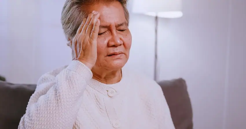 Person experiencing headache symptoms after a car accident