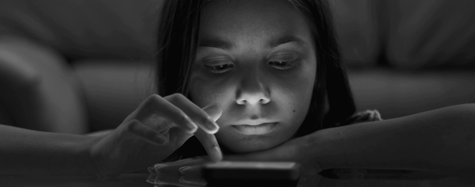 A child scrolling on their phone late represents a case of social media addiction where their parents will file a social media addiction lawsuit.