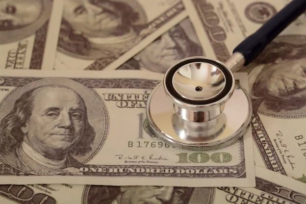 A stethoscope and money represent medical bills while a personal injury case is ongoing.